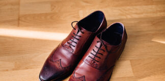 Red leather shoes stand on the light wooden floor
