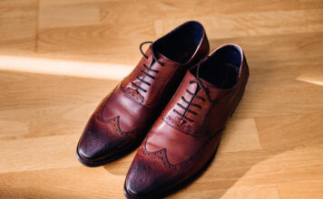 Leather Shoes vs Synthetic Shoes: Which Last Longer? Red leather shoes stand on the light wooden floor